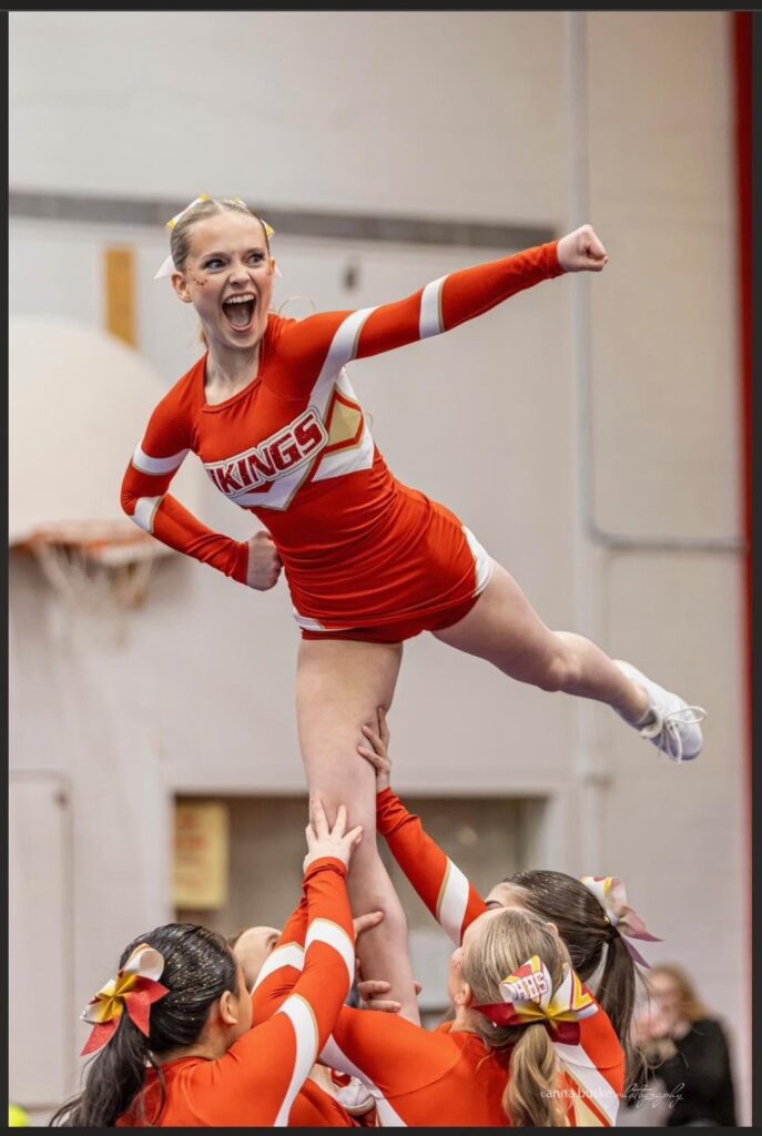 hammarskjold-cheerleading-team-competition-girls-holding-up-one-girl