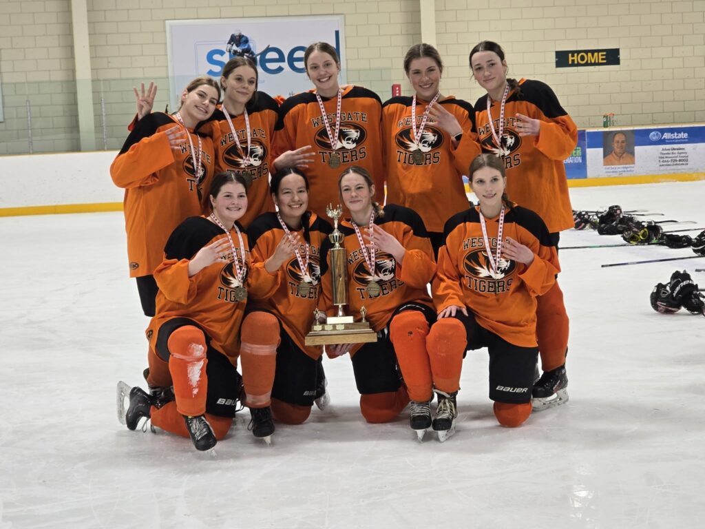 westgate-girls-hockey-team-posed-on-ice-with-trophy