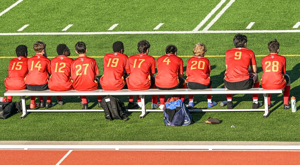 hammarskjold-boys-soccer-team-sitting-on-bench